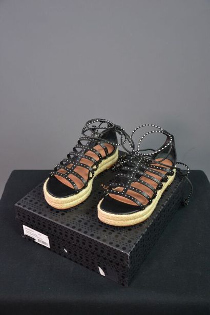 ALAIA Sandales compensées en cuir noir clouté....
