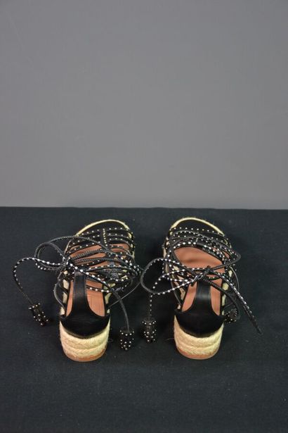 ALAIA Sandales compensées en cuir noir clouté....