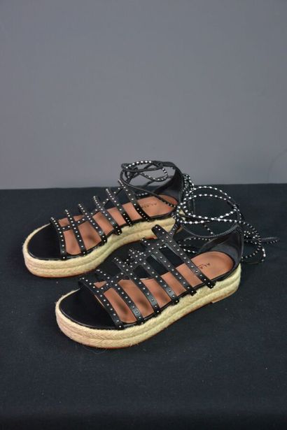 ALAIA Sandales compensées en cuir noir clouté....