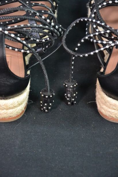 ALAIA Sandales compensées en cuir noir clouté....