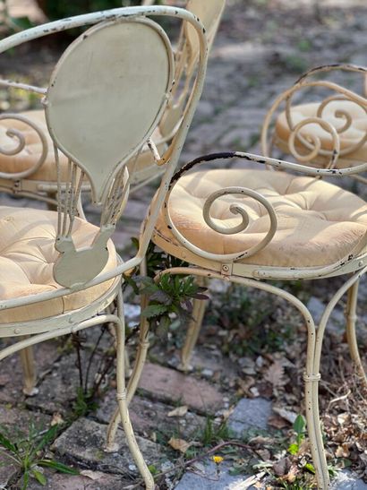 Four cream lacquered iron armchairs. Openwork...