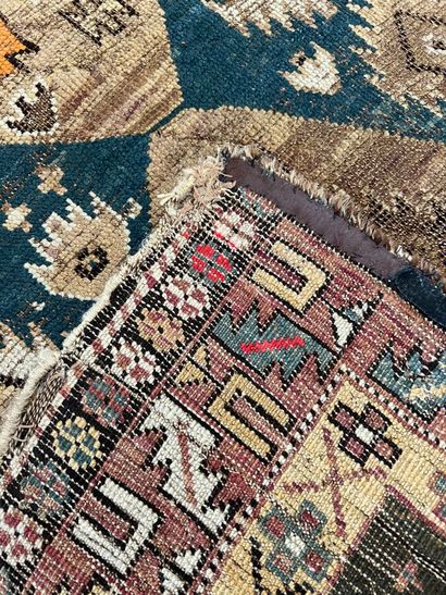 Oriental rug with blue background (many tears...