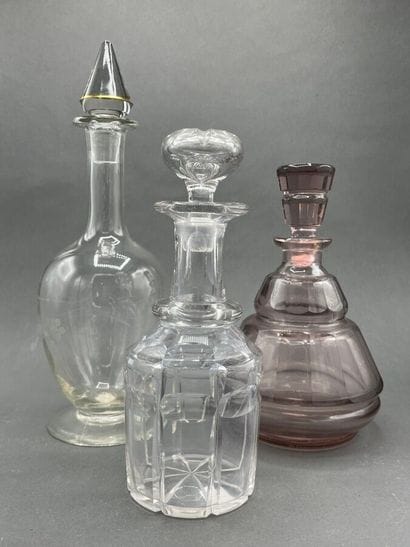Two cut-crystal carafes, one purple-tinted...