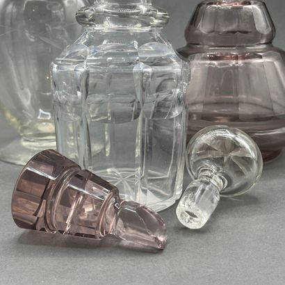 Two cut-crystal carafes, one purple-tinted...