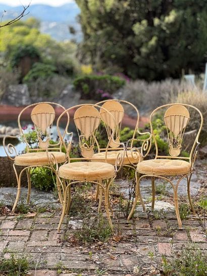 Four cream lacquered iron armchairs. Openwork...