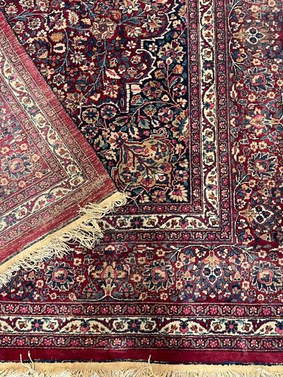 Persian rug with arabesque motifs on a red...