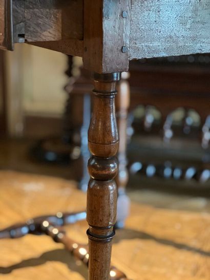 Table en noyer ouvrant par un tiroir en ceinture...