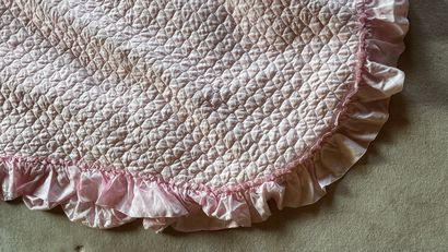 Quilted pink bedspread with frilly braid...