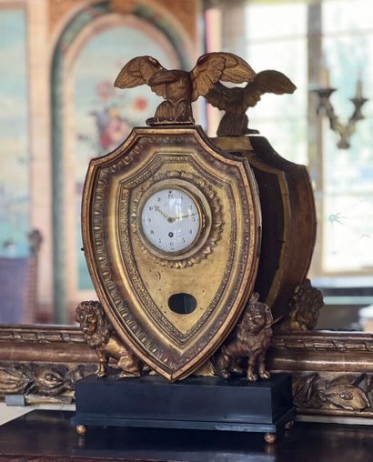 Pendule en bois sculpté et doré en forme...
