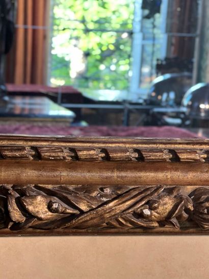 Grand miroir en bois sculpté et doré à décor...