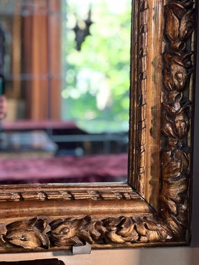 Grand miroir en bois sculpté et doré à décor...