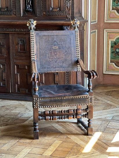 Armchair in natural wood, the uprights surmounted...