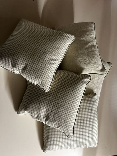 Five cushions, two in ecru fabric, three...