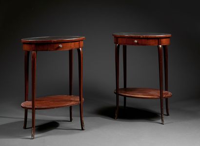 A pair of oval pedestal tables in veneered...
