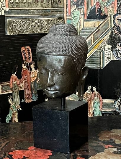 Resin Buddha head resting on a quadrangular...