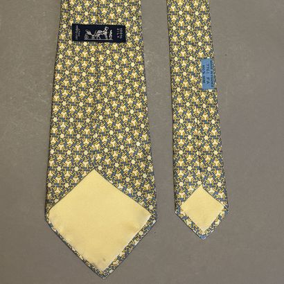 HERMES - Cravate en soie jaune à motif géométrique.
Griffée...