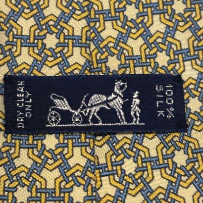 HERMES - Cravate en soie jaune à motif géométrique.
Griffée...