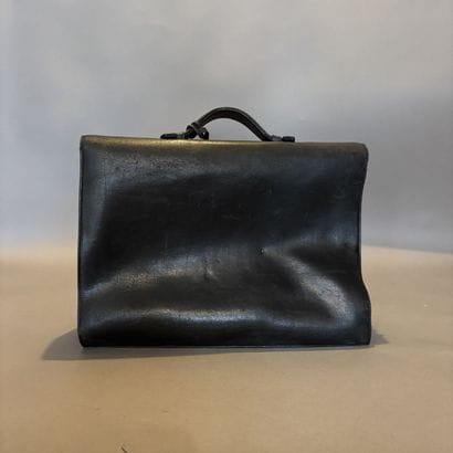 Sac à dépêche en cuir noir à double soufflet.
Tirette...