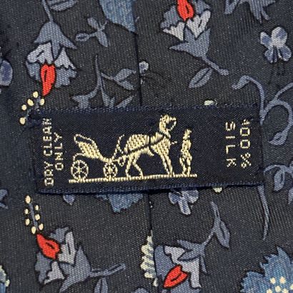 HERMES - Cravate en soie bleue à motif floral....