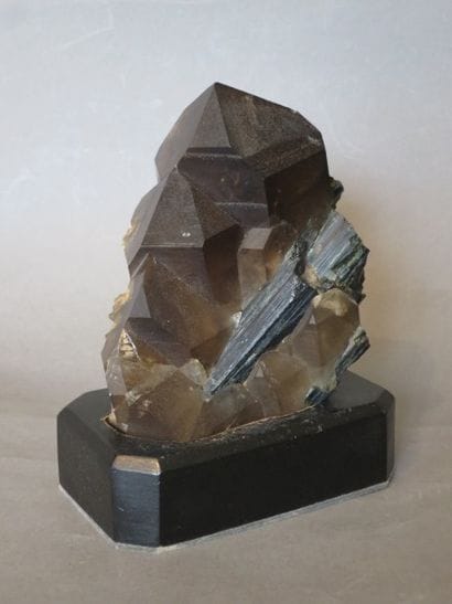 Morceau de cristal de roche fumé sur un socle...