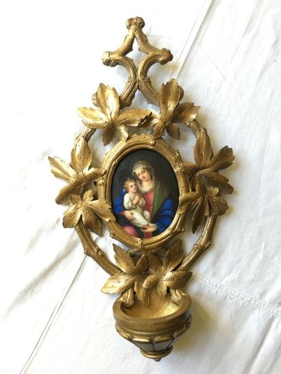 Un bénitier en bois sculpté et doré intégré...