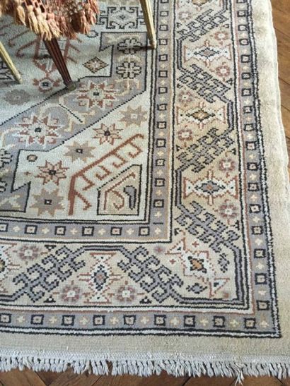 Tapis en laine beige à décor stylisé (usures)....