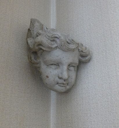 TÊTE D'ANGE en bois sculpté et laqué blanc.
XVIIIe...