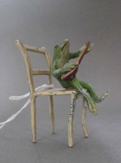 GRENOUILLE ASSISE sur une chaise jouant du...