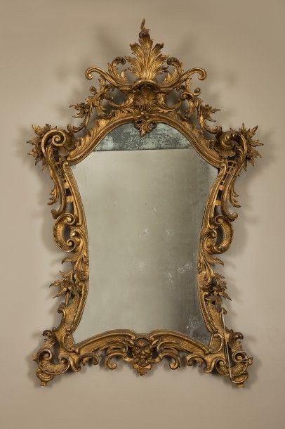 MIROIR en bois sculpté et doré à riche décor...