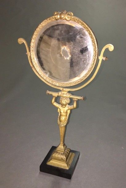 GLACE PSYCHÉ ronde en bronze tenue par un...