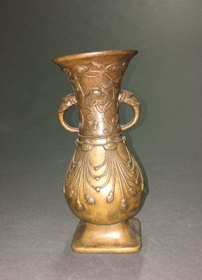 VASE en bronze à deux anses en forme de têtes...