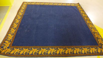 Tapis carré à fond bleu, la bordure ornée...