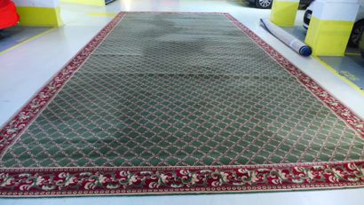 Très grand tapis fond vert à décor de croisillons,...