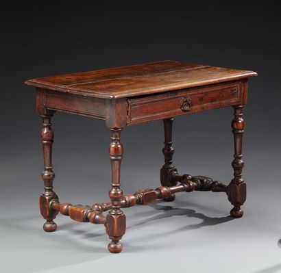 Table en bois naturel reposant sur quatre...
