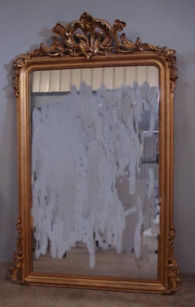 Grand miroir en bois et stuc doré à encadrement...
