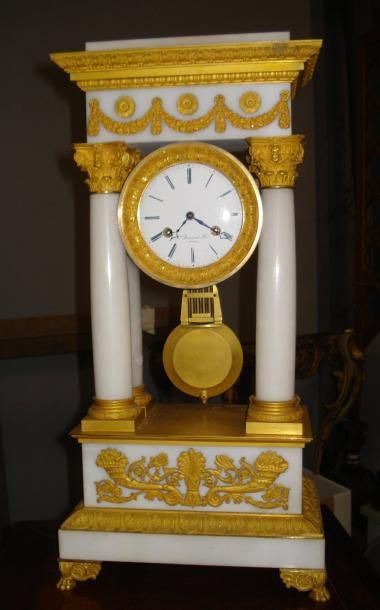 Pendule en albâtre et bronze ciselé et doré....