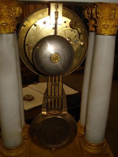 Pendule en albâtre et bronze ciselé et doré....