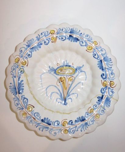 Plat creux godronné en faïence polychrome...
