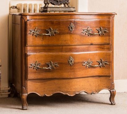 Commode galbée en noyer mouluré ouvrant à...