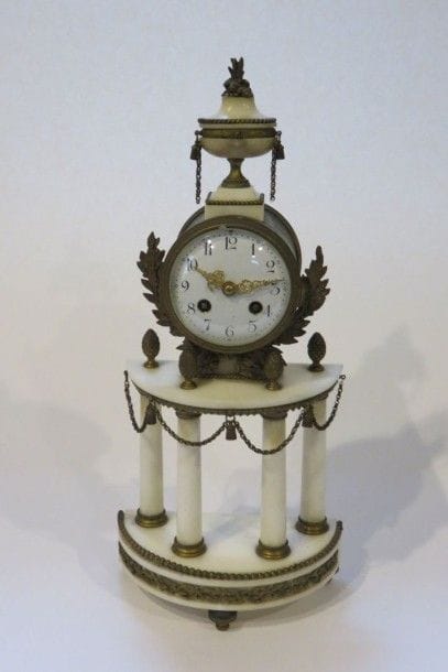 Pendule en marbre blanc et bronze doré. Un...
