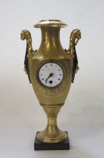 Pendule urne en porcelaine dorée et patinée...