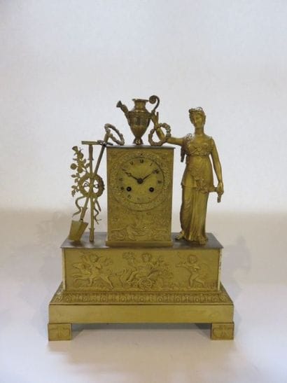 Pendule en bronze ciselé et doré aux attributs...