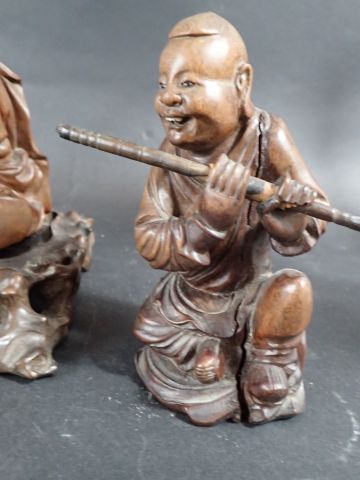 Trois sujets en bois sculpté, représentant...