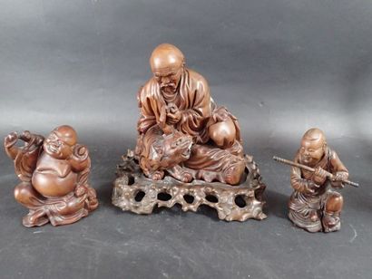 Trois sujets en bois sculpté, représentant...