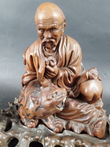Trois sujets en bois sculpté, représentant...