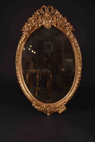 Important miroir ovale en bois sculpté et...