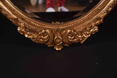 Important miroir ovale en bois sculpté et...