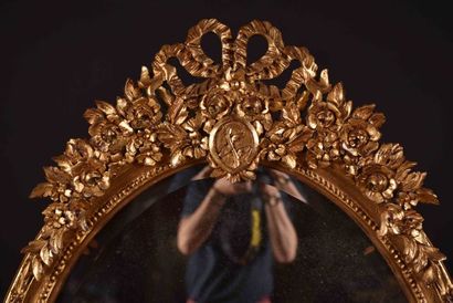 Important miroir ovale en bois sculpté et...