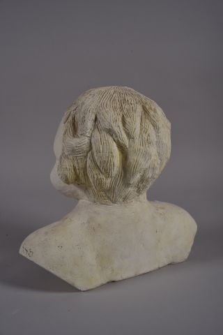 Buste d'enfant en plâtre. Signé sur l'épaule....
