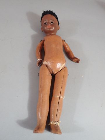 Poupée noire, tête en porcelaine. Corps articulé,...